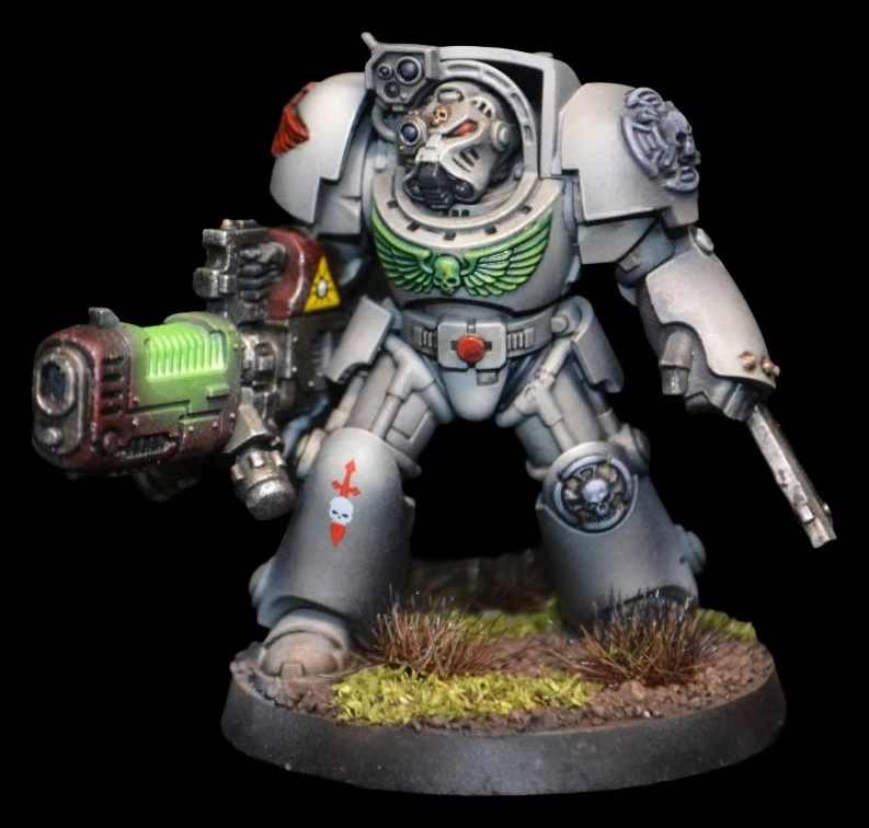 Deathwing Terminator in heller Rüstung mit grün leuchtender Plasmawaffe auf begrünter Base