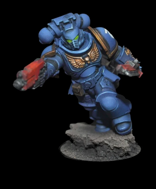 Ultramarines Intercessor in blauer Rüstung mit goldenen Details, roten Waffen und grünen Augen auf felsiger Base